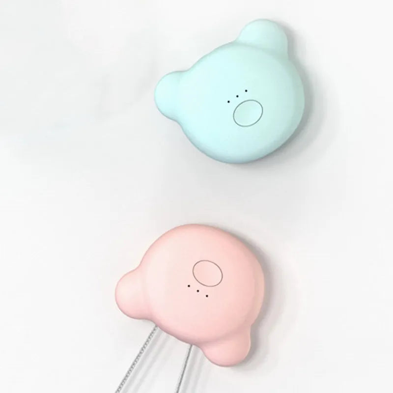 Compact pink USB air purifier necklace on a table with charging cable, showing dimensions 1.5 by 5.7 cm.