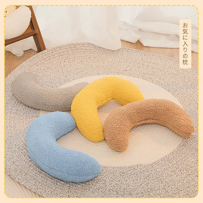 U-shaped blue cat pillow with adjustable neck collar on a sofa