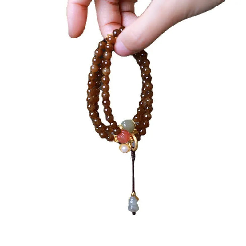 Brown jade women's bracelet with silver butterfly charm and three-ring design.