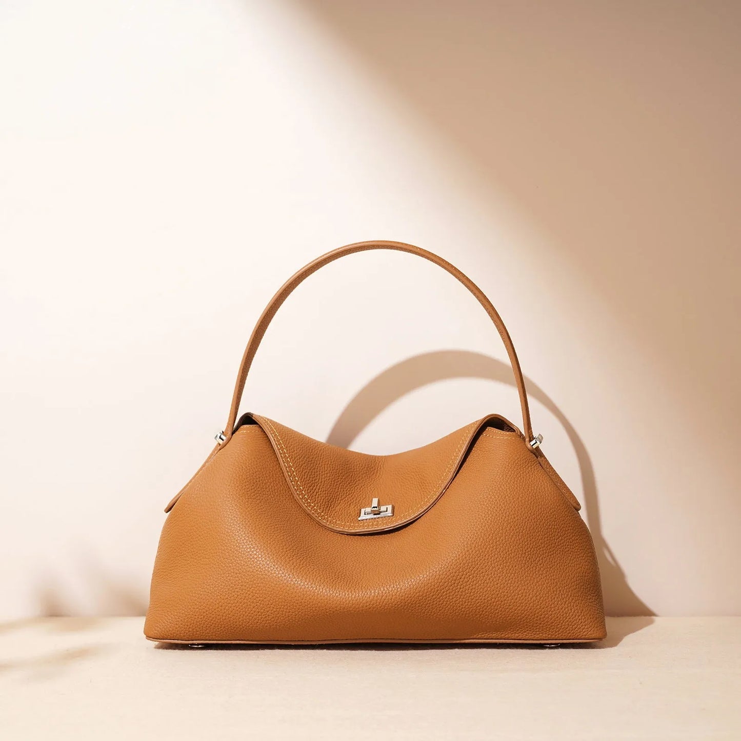 Cowhide leather shoulder messenger bag in a pillow shape with an open pocket and adjustable double straps.