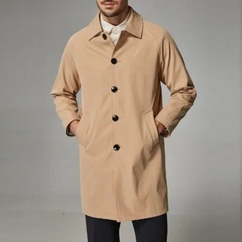 Man wearing a khaki coloured loose fit mid-length trench coat made from rabbit fur fabric.