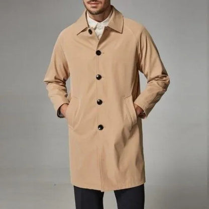 Man wearing a khaki coloured loose fit mid-length trench coat made from rabbit fur fabric.