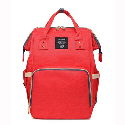 Stylish maternity diaper bag in various colors, featuring a paper bag design, separate bottle compartment, and discreet breastfeeding button.