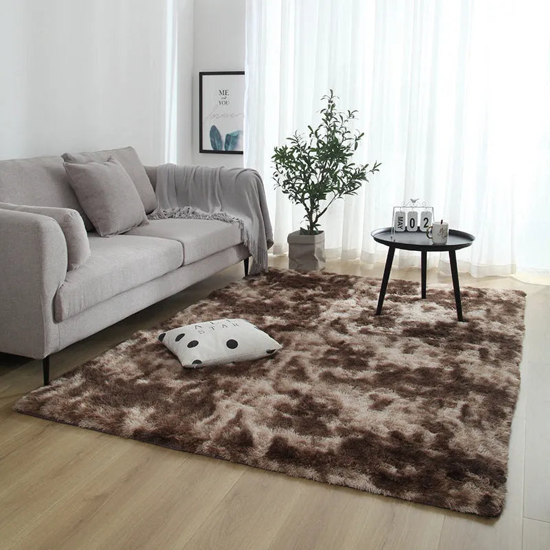 Soft fluffy plain rectangle carpet with anti-slip dots on backing, shown in a light grey colour on a wooden floor.