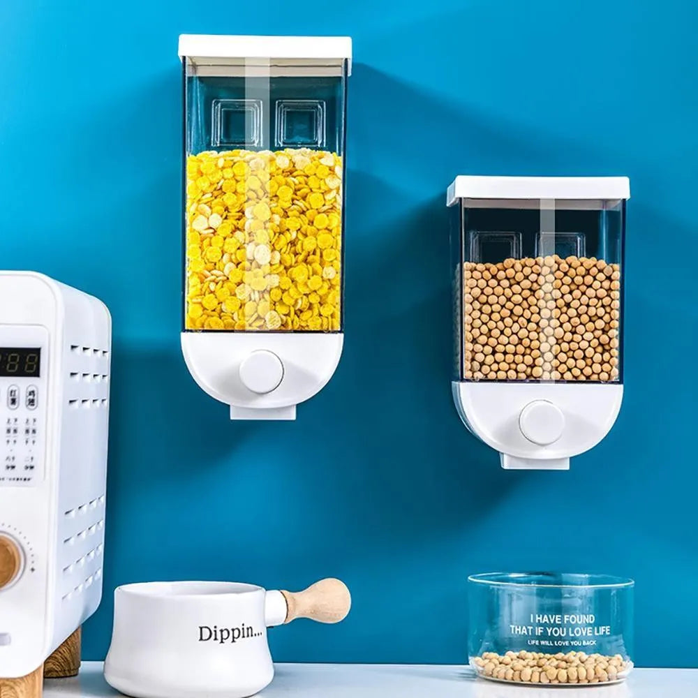 White wall-mountable kitchen food storage box with press lid dispenser, showing transparent body with cereal inside.