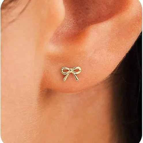 Women's gold bow cross stud earrings in zinc alloy with geometric design