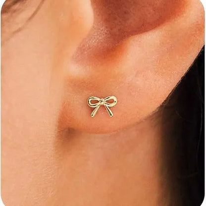 Women's gold bow cross stud earrings in zinc alloy with geometric design