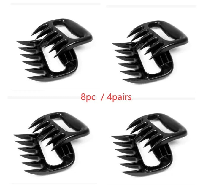 Two black bear claw meat shredding forks with non-slip grips for barbecue preparation