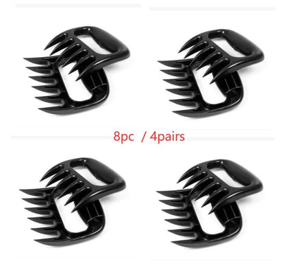 Two black bear claw meat shredding forks with non-slip grips for barbecue preparation