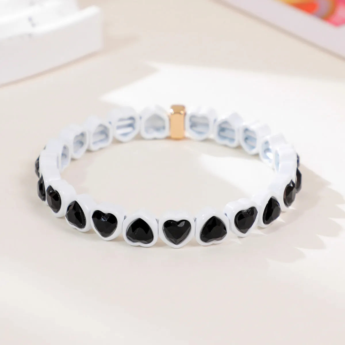 Colourful enamel heart shape on a silver-toned alloy stretch bracelet.