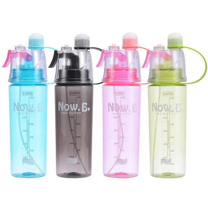 Green mist spray water bottle with clear volume scale and leakproof lid on a wooden table.