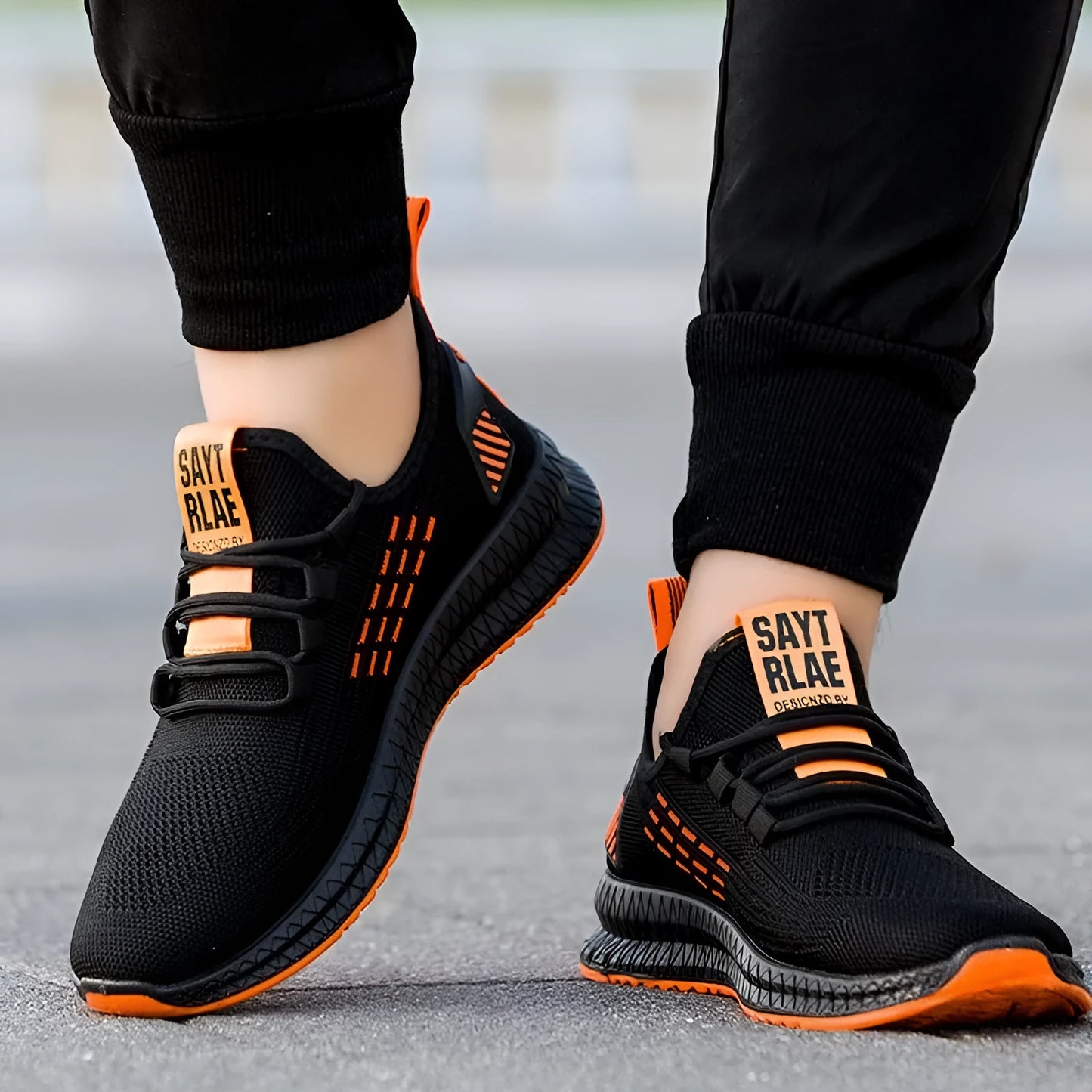 Men's black casual sports shoes with cross-strap detail and a Flying Weave upper, shown on a white background.