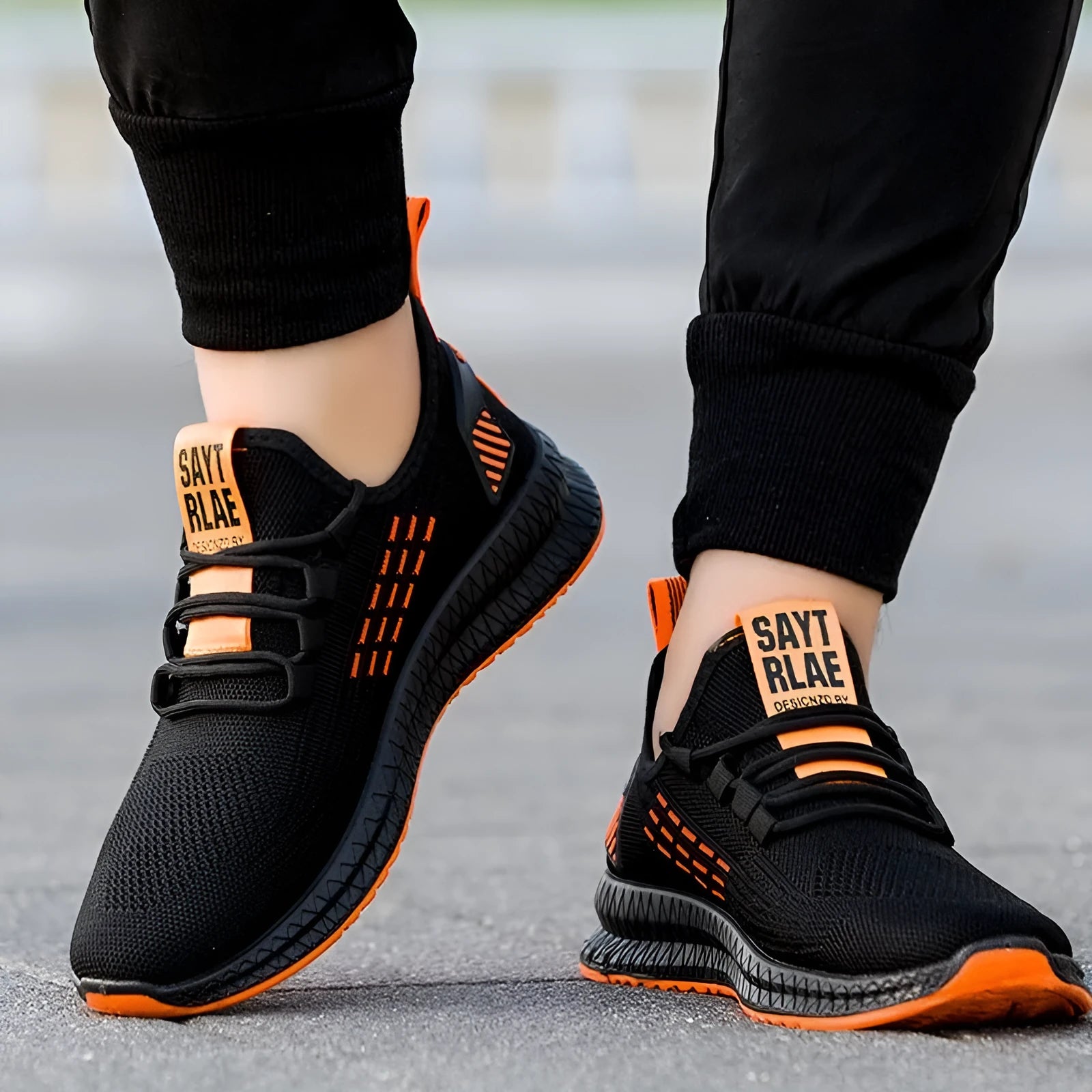 Men's black casual sports shoes with cross-strap detail and a Flying Weave upper, shown on a white background.