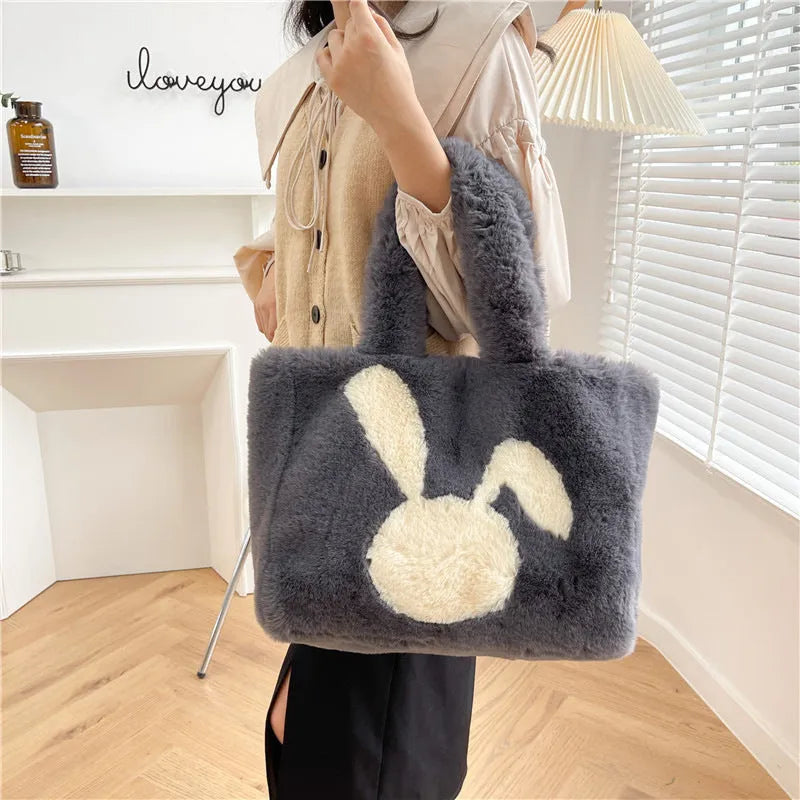 Soft plush tote bag with cartoon rabbit ears in solid colours like beige, pink, and black.