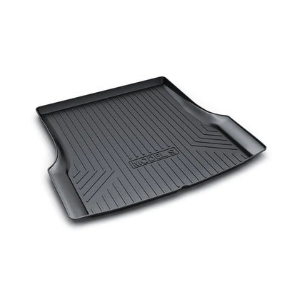 Custom black rubber floor mats fitted in a Tesla Model 3, showing textured surface and TPE driver footrest.