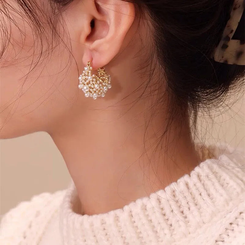 Gold-coloured women's floral basket earrings made from copper with small bead and pearl inlay detail.