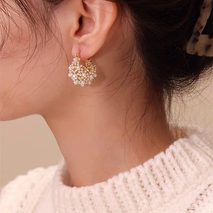 Gold-coloured women's floral basket earrings made from copper with small bead and pearl inlay detail.
