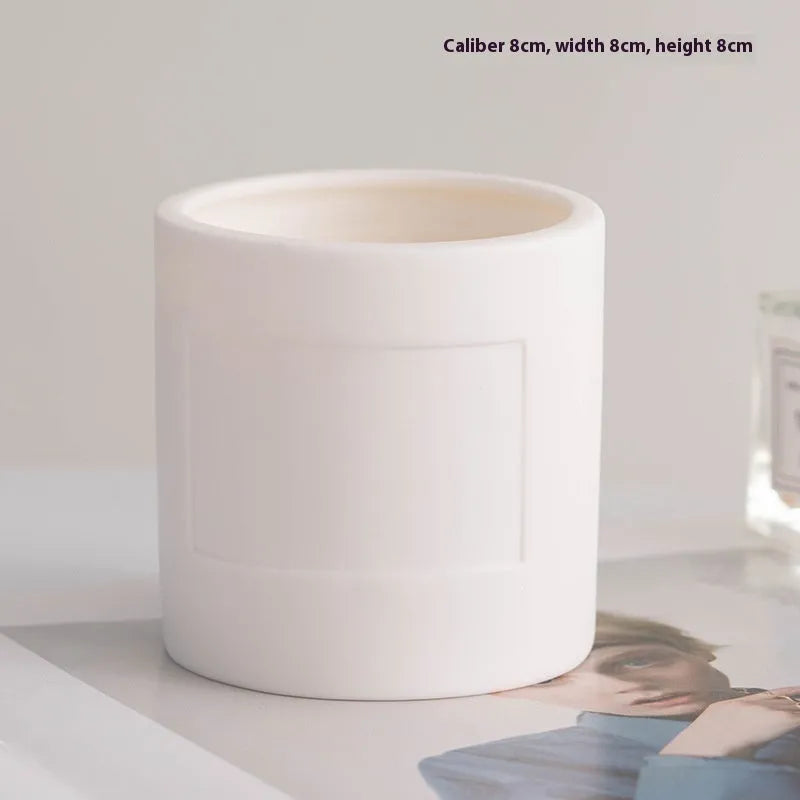Set of ten round white ceramic candlesticks with minimalist relief patterns on a dining table