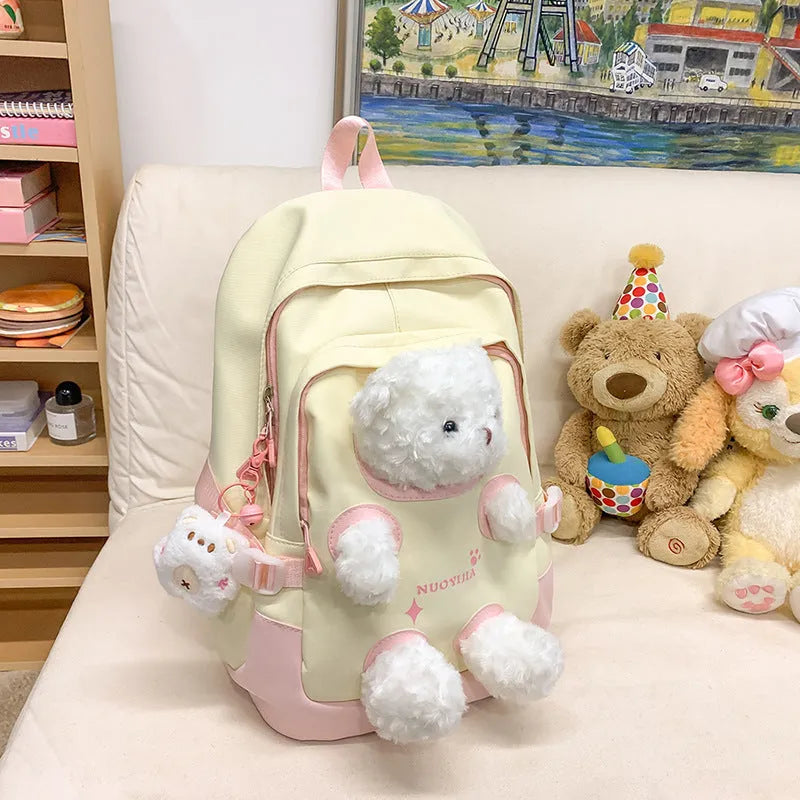 Macaron colour nylon school backpack with curved straps, shown in yellow pink, with a pendant attached.