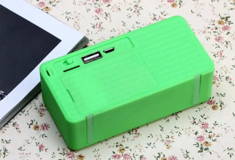 Cannon X3 small cube-shaped wireless Bluetooth speaker in multiple colours on a table.