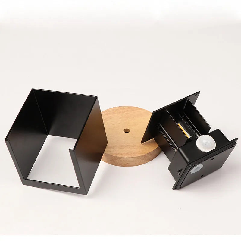 Compact square aluminium wall lamp with 360-degree light output, shown in grey finish mounted on a wall.
