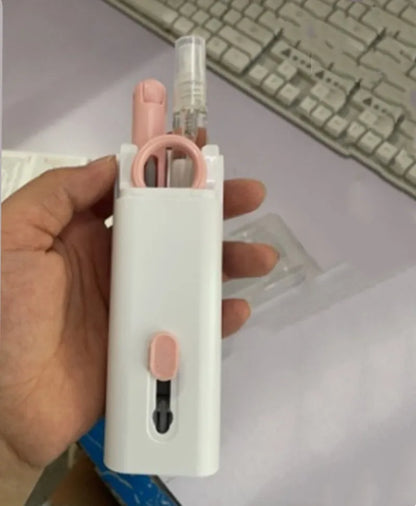 White electronics cleaning kit with a cleaning pen, spray bottle, brush, and keycap puller on a table