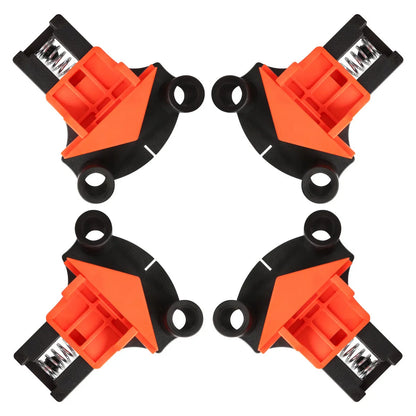 Four white plastic right angle clamps for woodworking and picture frame assembly on a workbench.