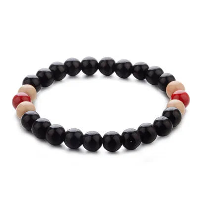 An ethnic-style natural stone bead bracelet with lava stones on a wrist.