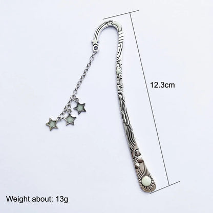 Retro five-pointed star glowing metal bookmark in ancient silver and bronze finishes on an open book.