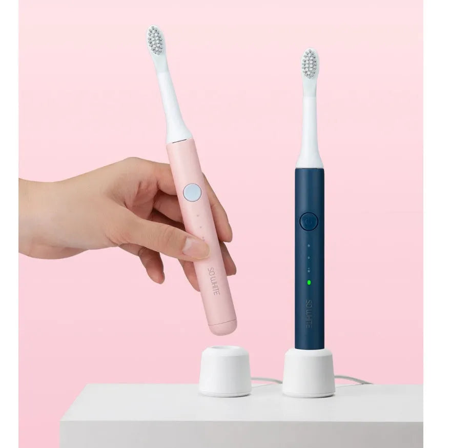 SOOCAS sonic electric toothbrush in blue or pink with round brush head on a bathroom counter.