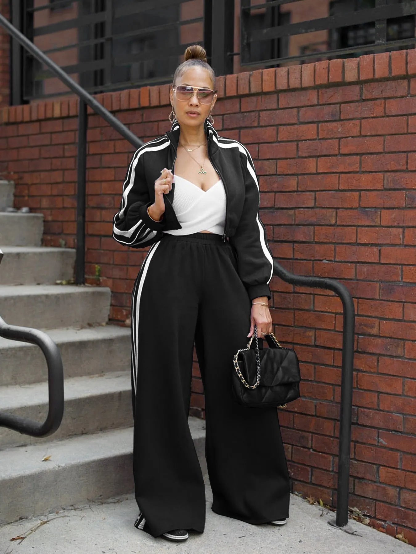 Woman wearing a grey striped zipper sweater and matching trousers from a casual two-piece set.
