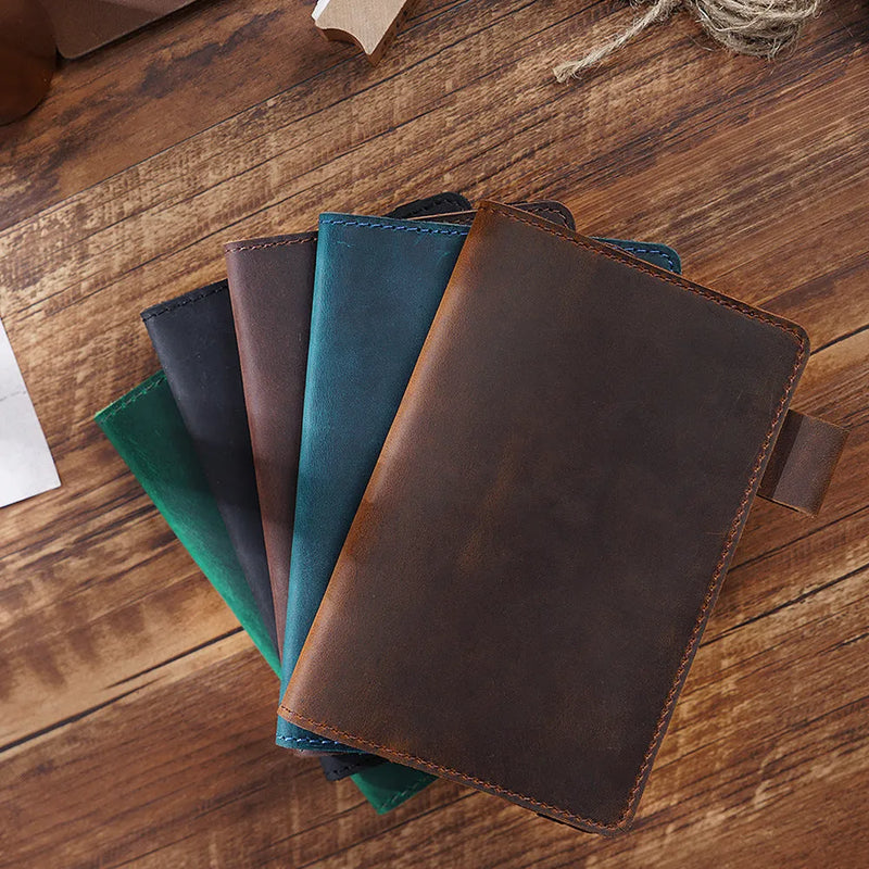 Handmade notebook with first layer cowhide cover and 100 sheets of wood-free paper, measuring 9x14cm in six traditional colours including dark green, black, and burgundy for journaling and sketching.