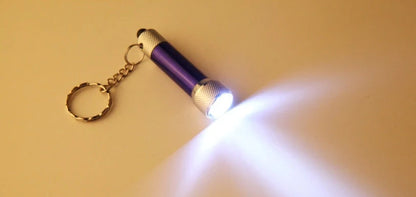 Compact aluminium LED keychain torch in four colours: white, black, red, and blue.
