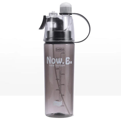 Green mist spray water bottle with clear volume scale and leakproof lid on a wooden table.