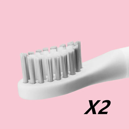 SOOCAS sonic electric toothbrush in blue or pink with round brush head on a bathroom counter.