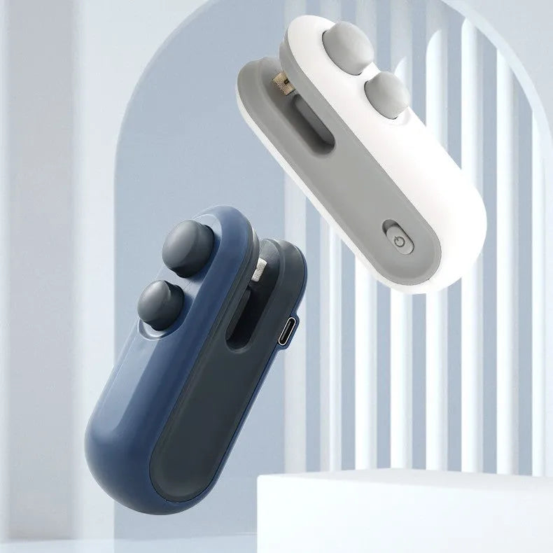 Handheld white portable heat sealer with USB Type-C port and magnetic back on a metal surface.