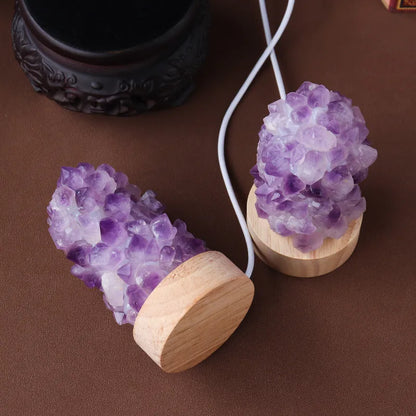 Mini USB night light glowing inside a natural amethyst crystal vug geode on a dark surface.
