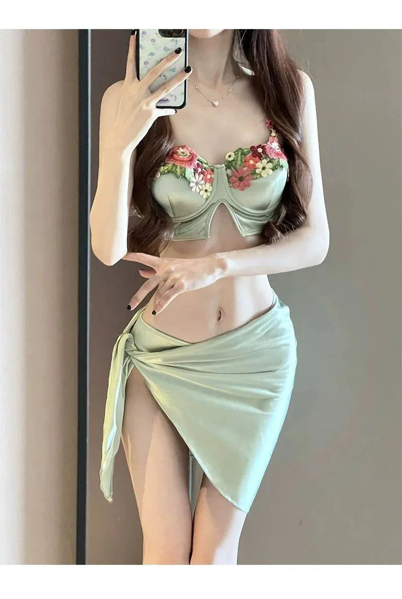 Green women's bikini three-piece set with triangle top, pants, and skirt