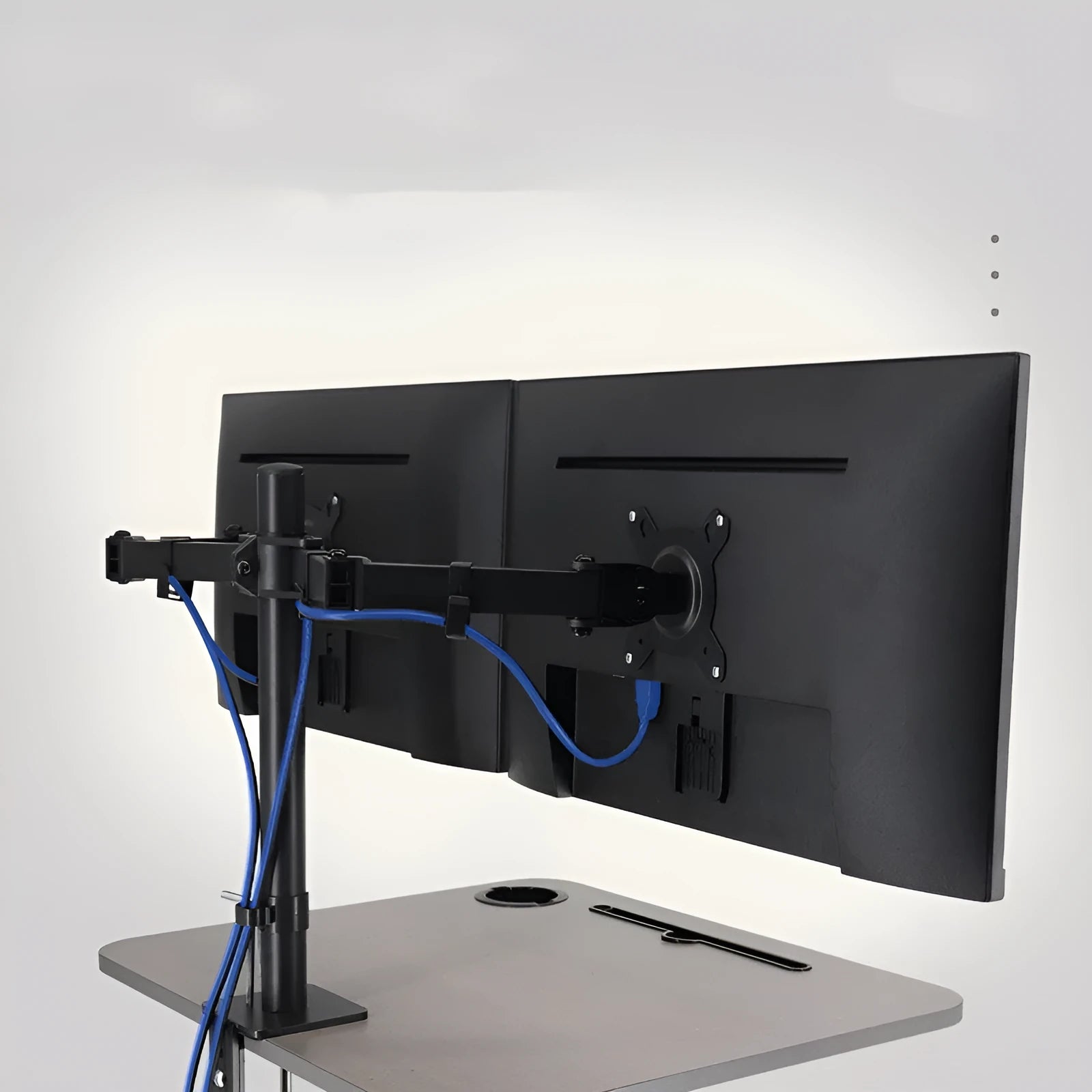 Silver computer monitor lifting rotating arm bracket mounted with a black screen on a desk