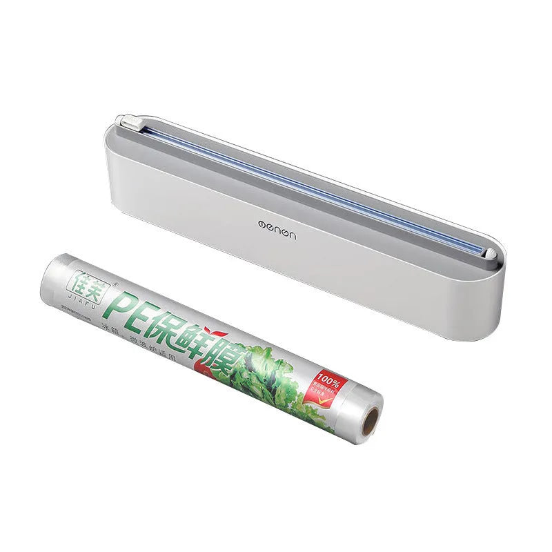 Black plastic cling film cutter and dispenser unit mounted on a refrigerator door.