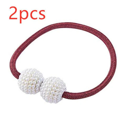 Magnetic curtain tiebacks with white pearl beads and fabric loops holding gathered curtain