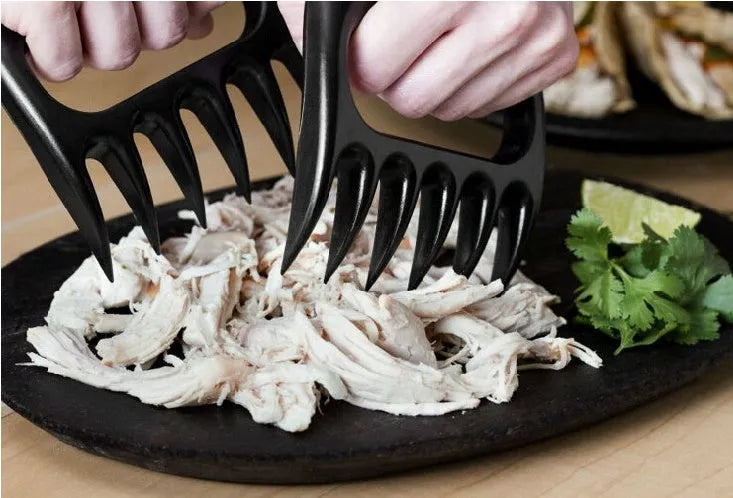 Two black bear claw meat shredding forks with non-slip grips for barbecue preparation