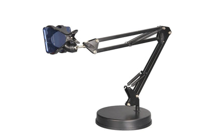 Black metal adjustable phone and tablet stand with a heavy round base on a wooden desk