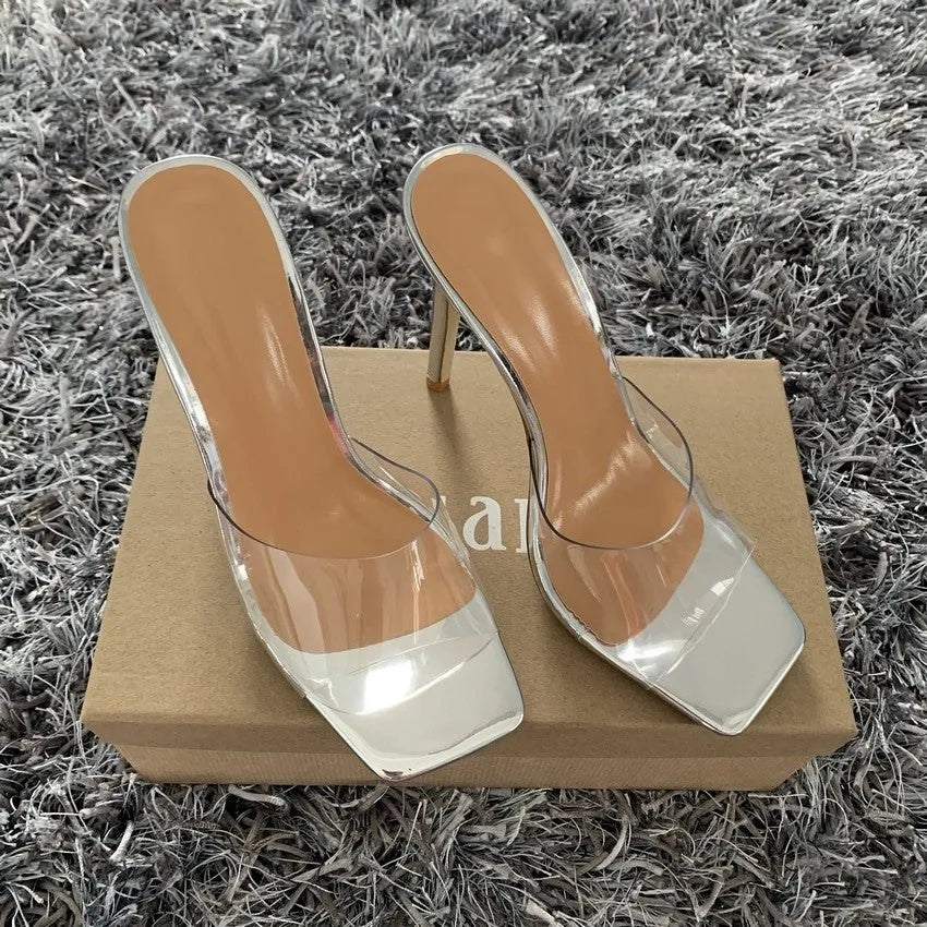 A pair of women's black and silver high heel boots with a PVC sole on a white background.