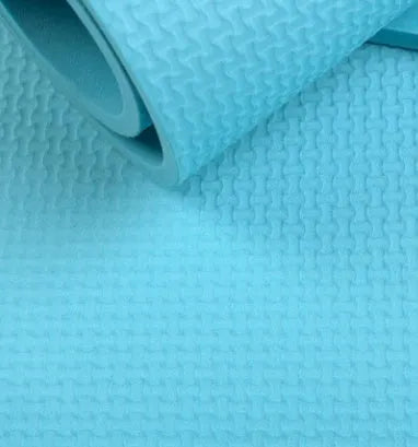 EVA composite fitness and yoga mat in blue, showing its texture and rolled edge next to a storage bag.