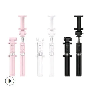 Aluminium tripod selfie stick with extended phone clip and Bluetooth remote on a table