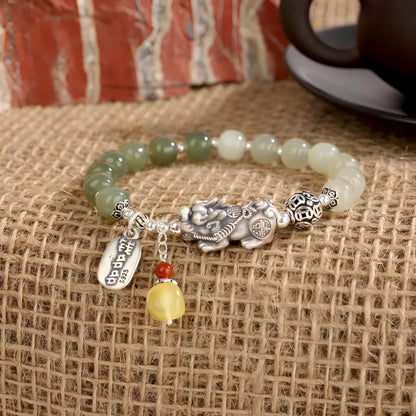 Close-up of a retro-style sterling silver coin bracelet with natural Hetian jade beads for women.