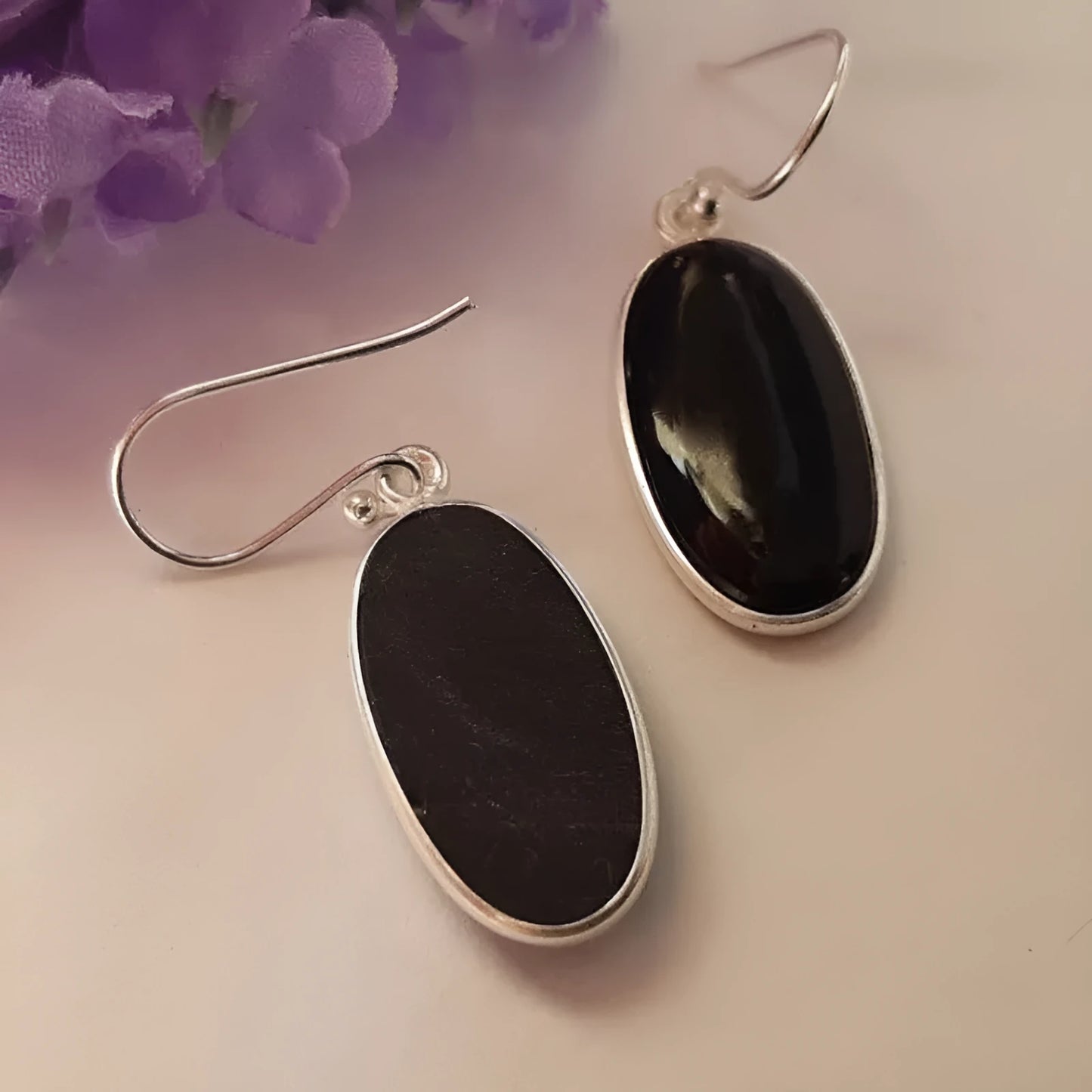 A pair of women's silver-plated alloy earrings with an oval black agate geometric pendant.