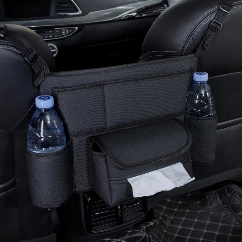 Black leather car seat gap storage bag hanging from armrest with tissue box, showing textured grain detail.