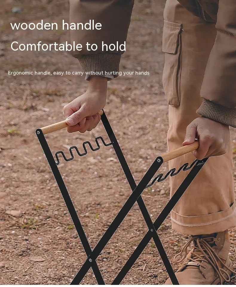 Black outdoor folding trash rack with wooden handle, holding a waste bag.